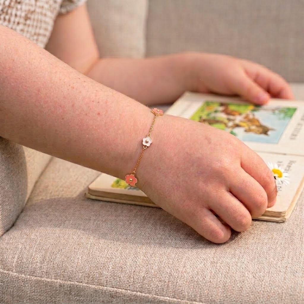 Child wearing 14K solid gold pink and white flower epoxy bracelet, 5.5 inch size