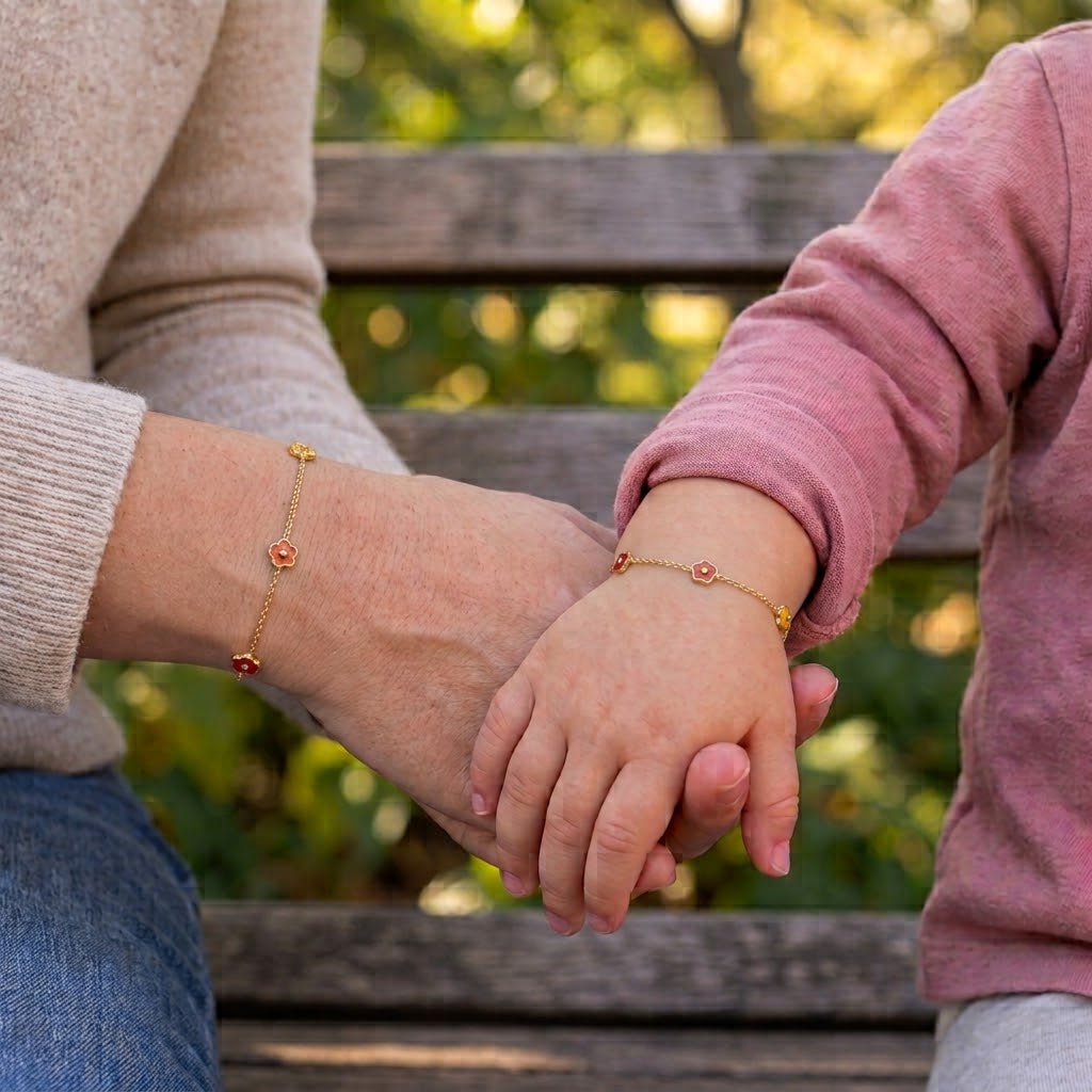 Mommy and child wearing matching 14K solid gold red, orange, and yellow flower bracelets
