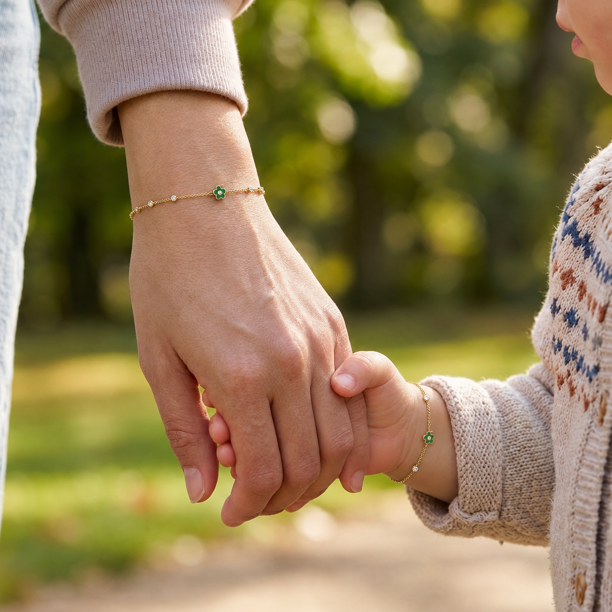 Mommy and child wearing matching 14K solid gold green flower bracelets