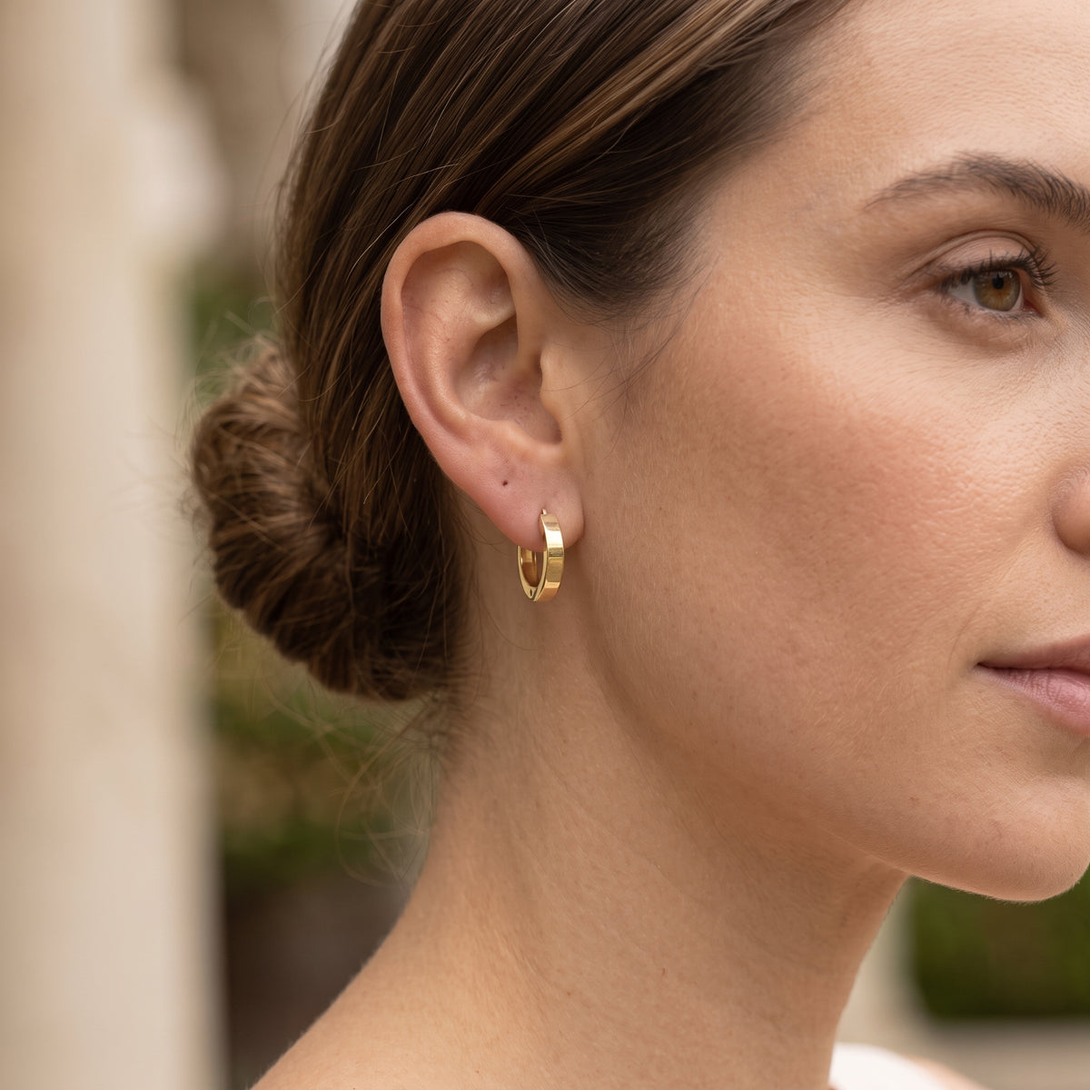 14K solid gold polished snap hoop earrings worn in ear