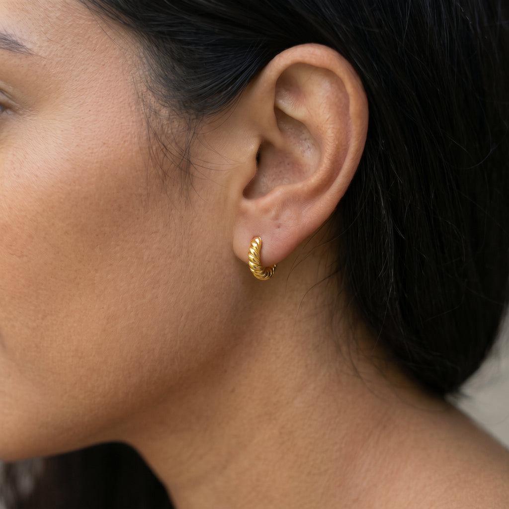 14K solid gold twisted huggie hoop earrings worn in ear