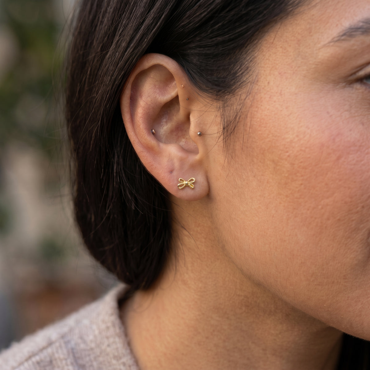 14K solid gold bow stud earrings worn in ear