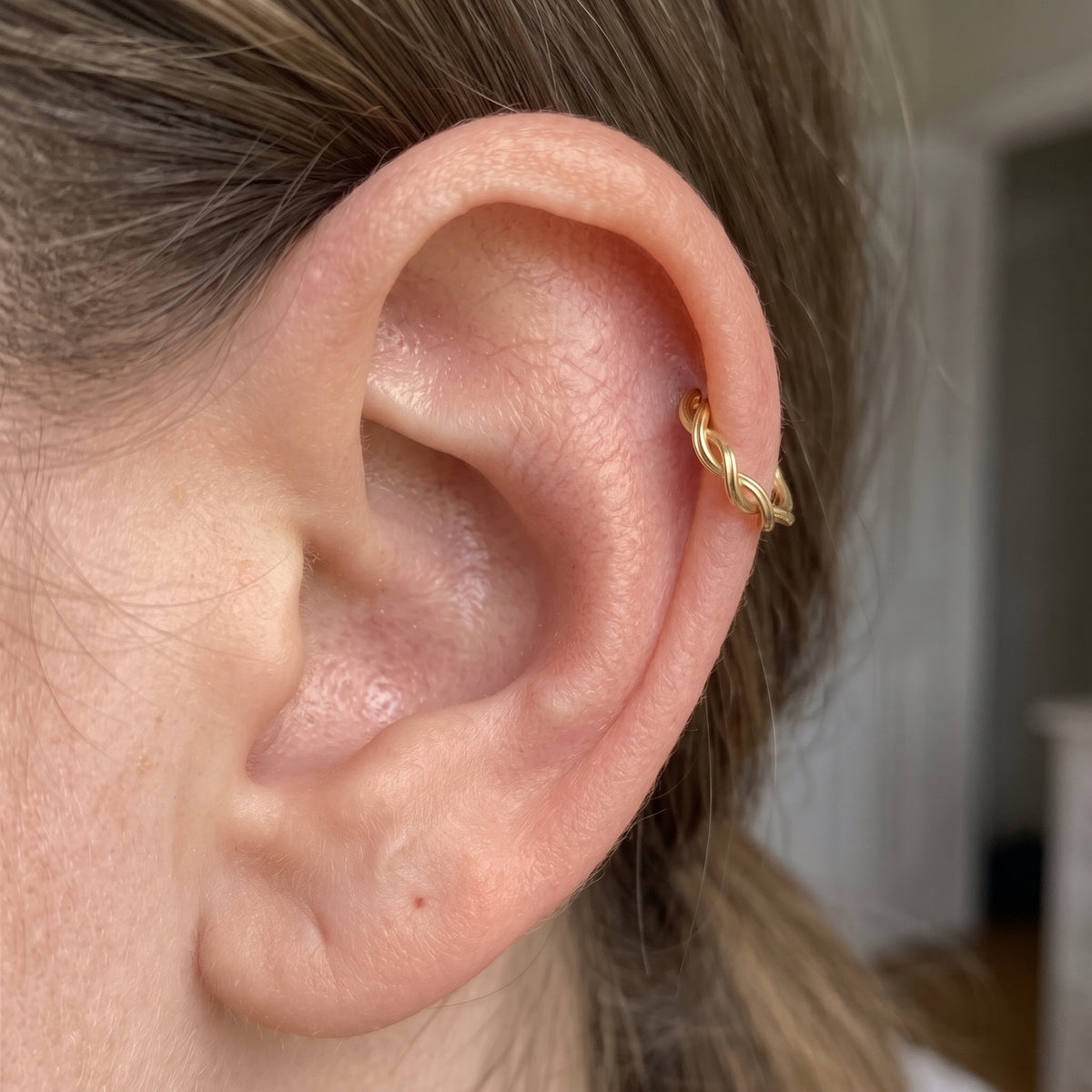 10K solid gold braided clicker hoop worn in cartilage piercing